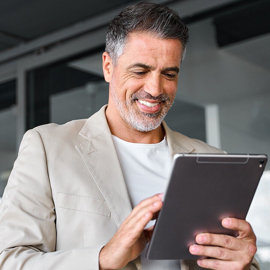 Man looking at his tablet, smiling. 