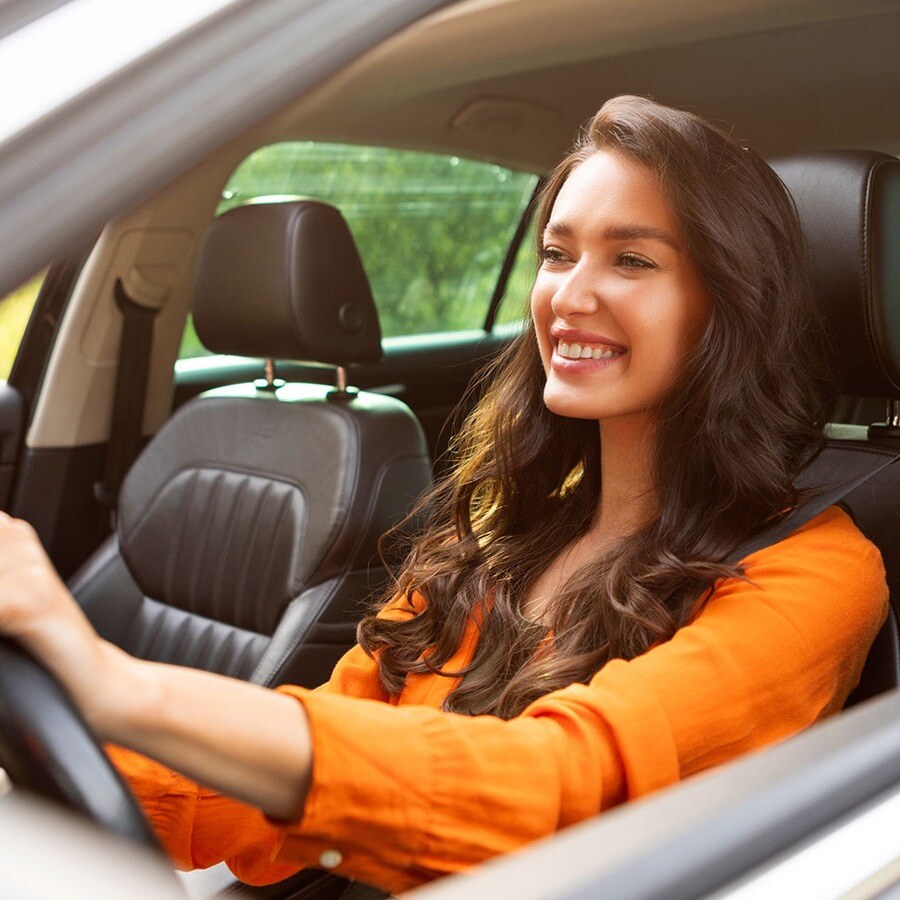Younger smiling girl at the wheel of her new car. 